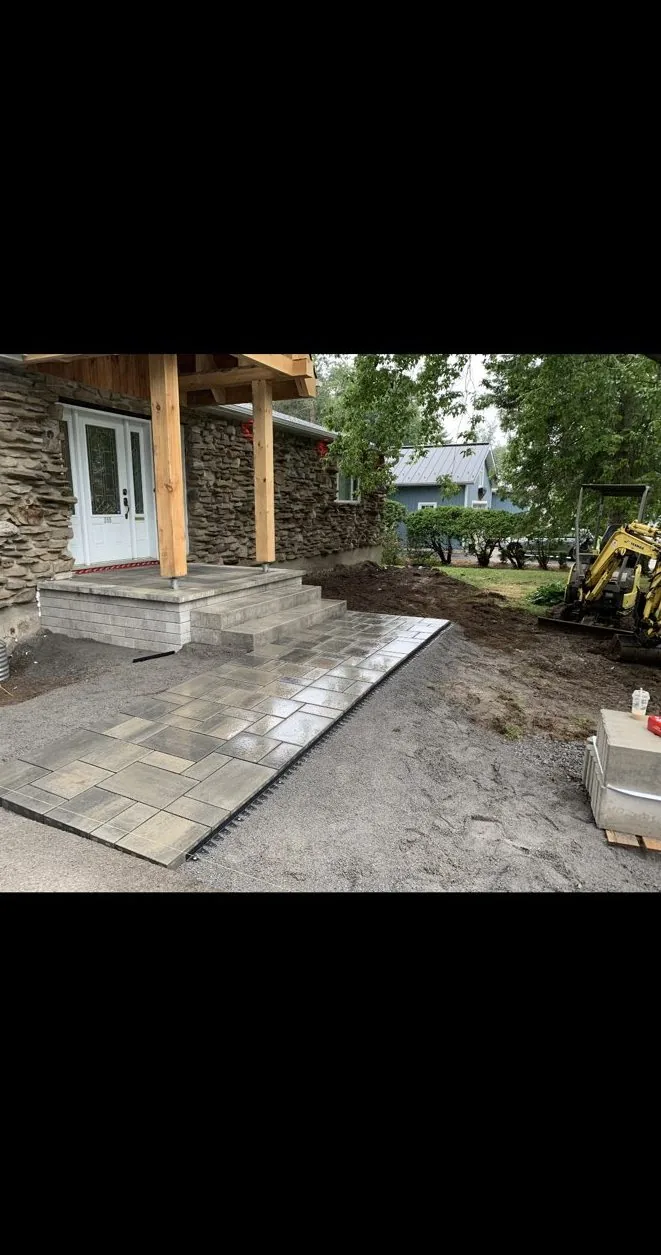 Allée et marches d'entrée en pavé uni devant une maison en pierre